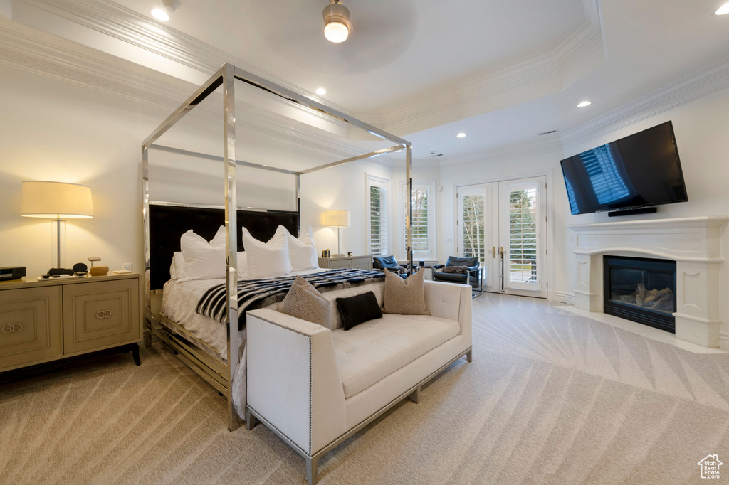 Carpeted bedroom with french doors, a tray ceiling, ceiling fan, ornamental molding, and access to exterior