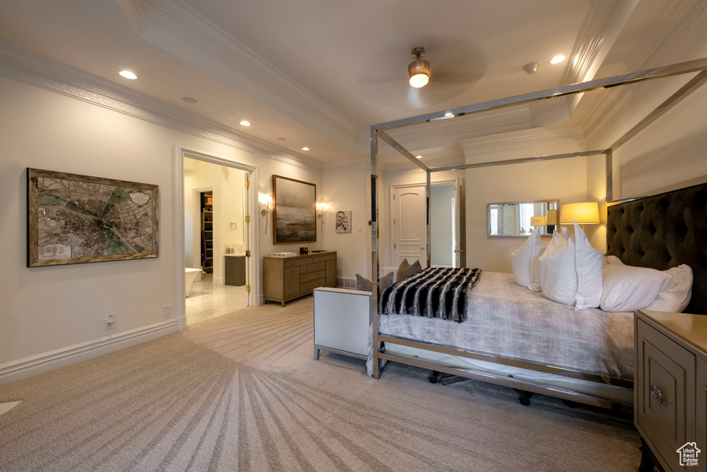 Bedroom featuring light colored carpet, a tray ceiling, ornamental molding, and ceiling fan