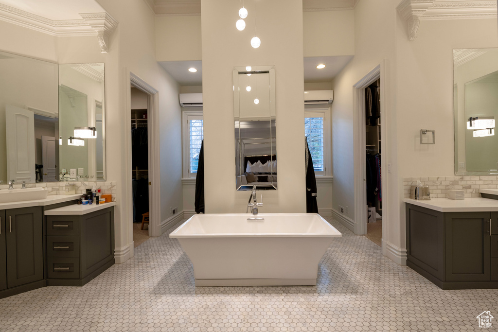 Bathroom featuring a washtub, tasteful backsplash, large vanity, tile flooring, and ornamental molding