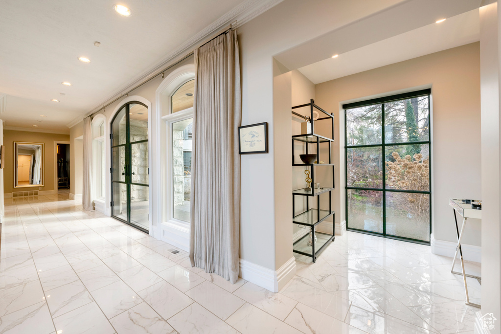 Interior space with crown molding and light tile flooring