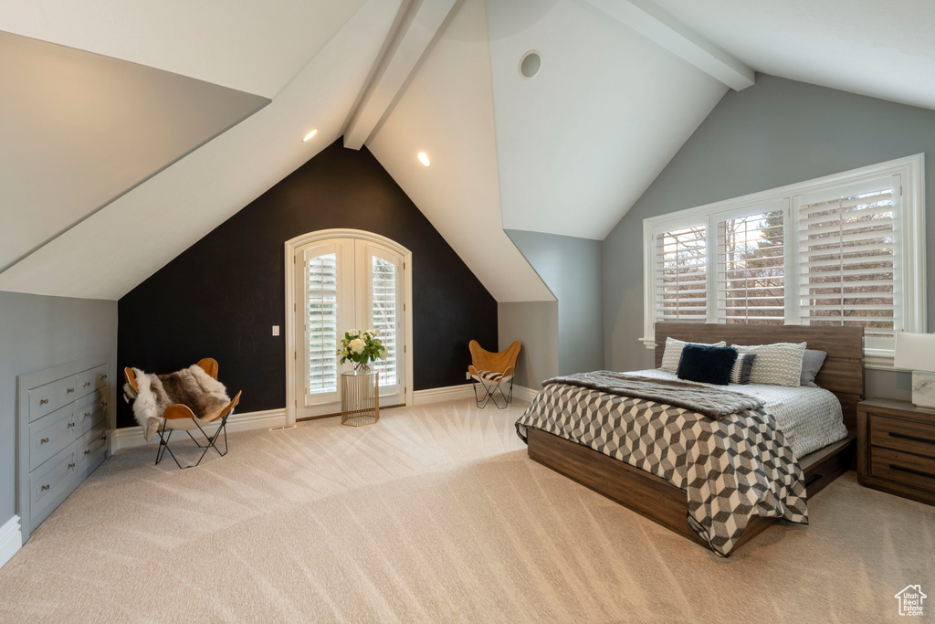Carpeted bedroom featuring vaulted ceiling with beams
