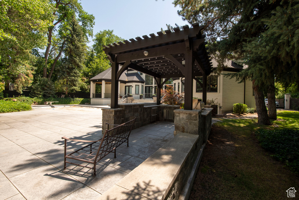 View of patio with a pergola and area for grilling