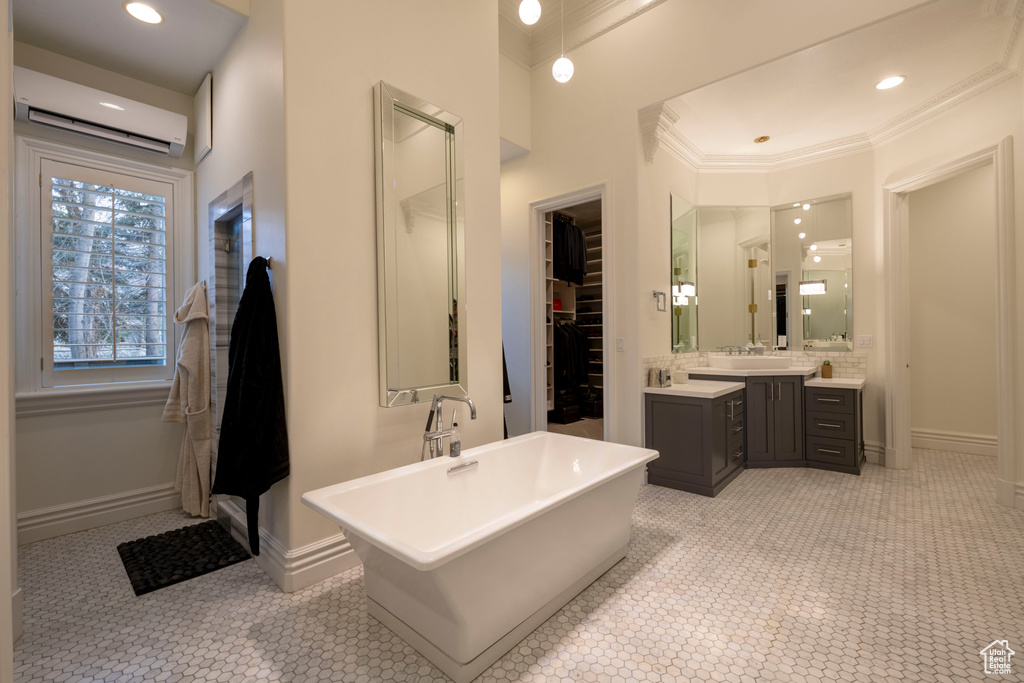 Bathroom with backsplash, vanity, a wall mounted air conditioner, a bathtub, and tile flooring