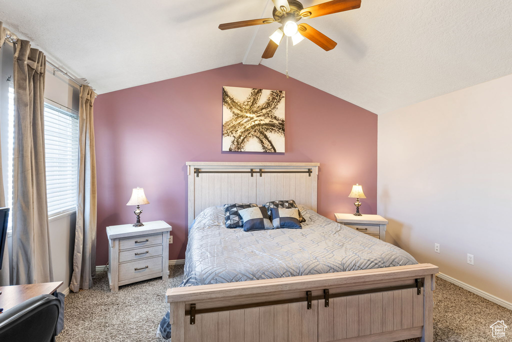 Bedroom with light colored carpet, ceiling fan, and lofted ceiling
