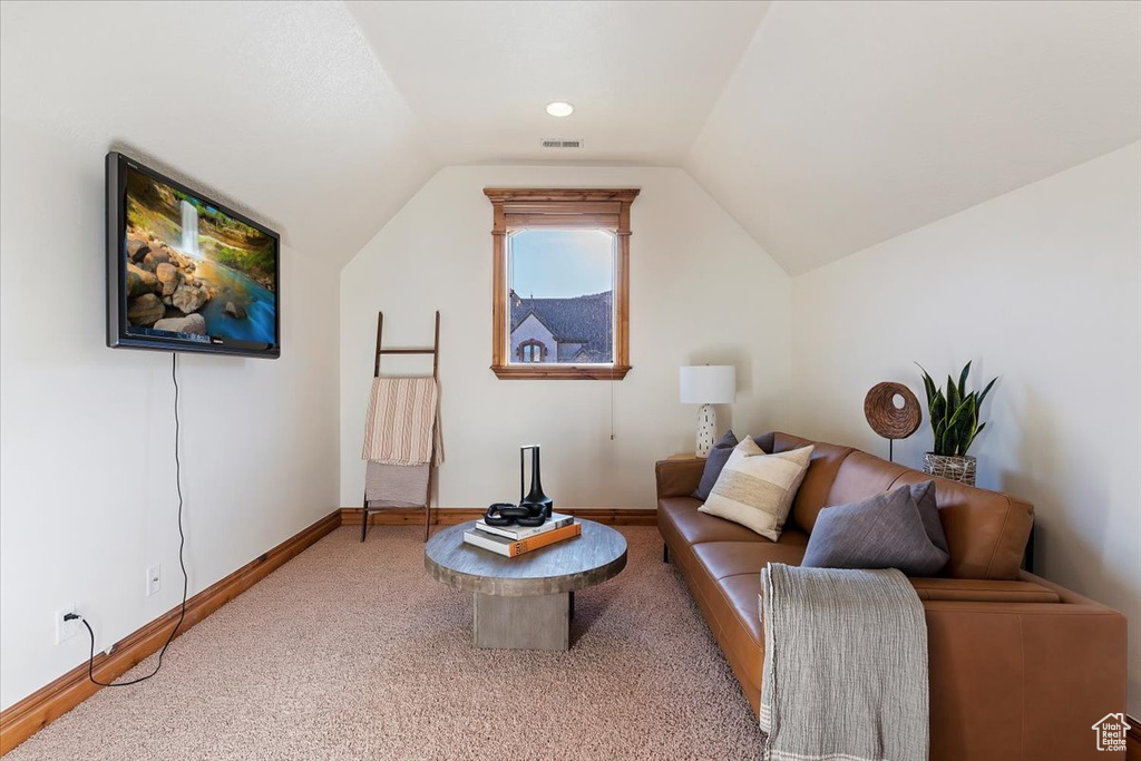 Living room featuring light colored carpet and lofted ceiling