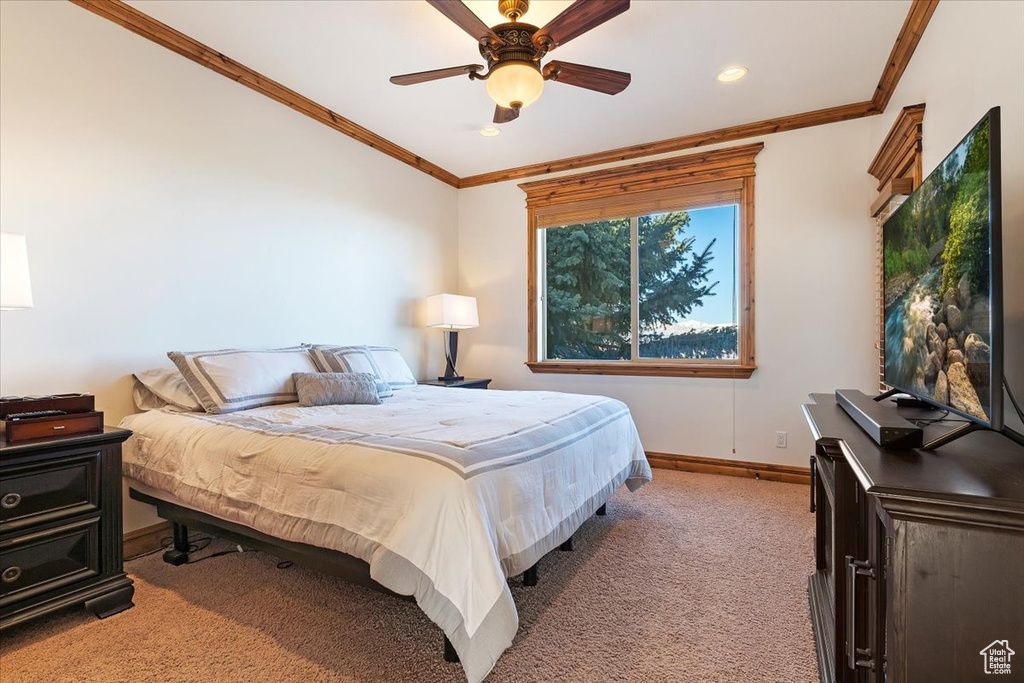 Bedroom with light carpet, ornamental molding, and ceiling fan