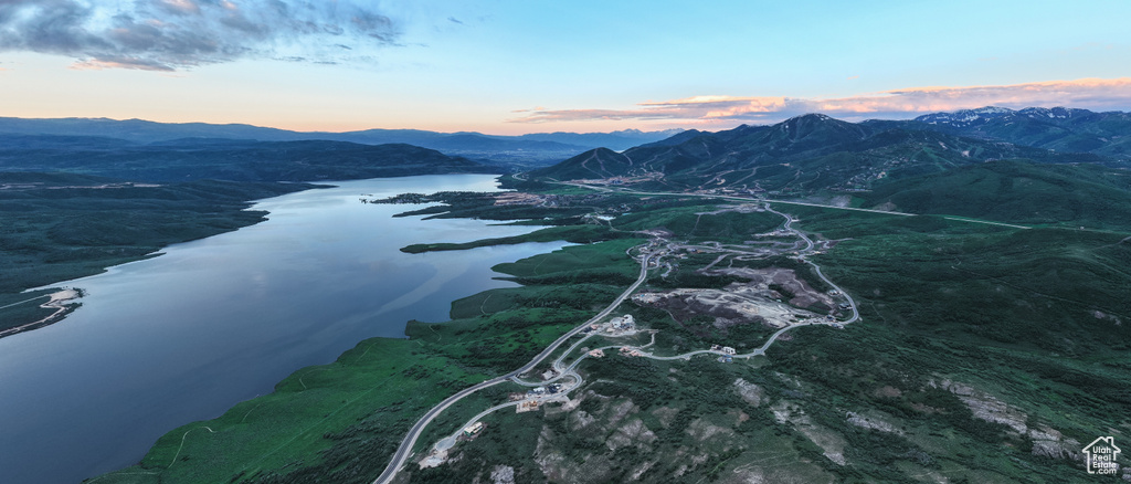 Aerial view at dusk featuring a water and mountain view