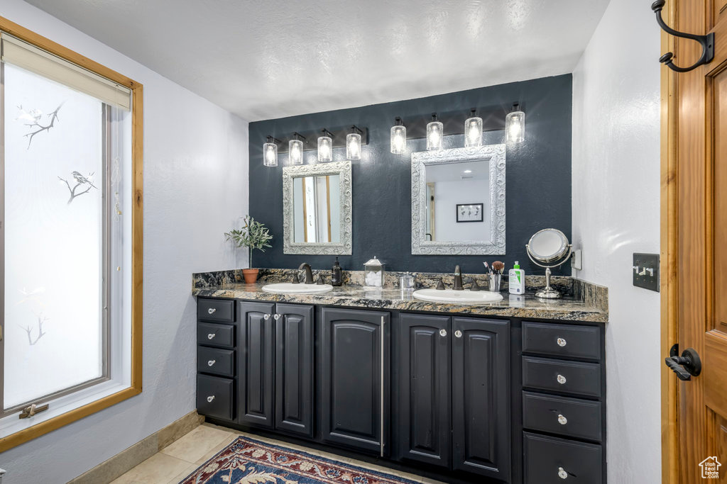 Bathroom with tile flooring, double sink, and vanity with extensive cabinet space