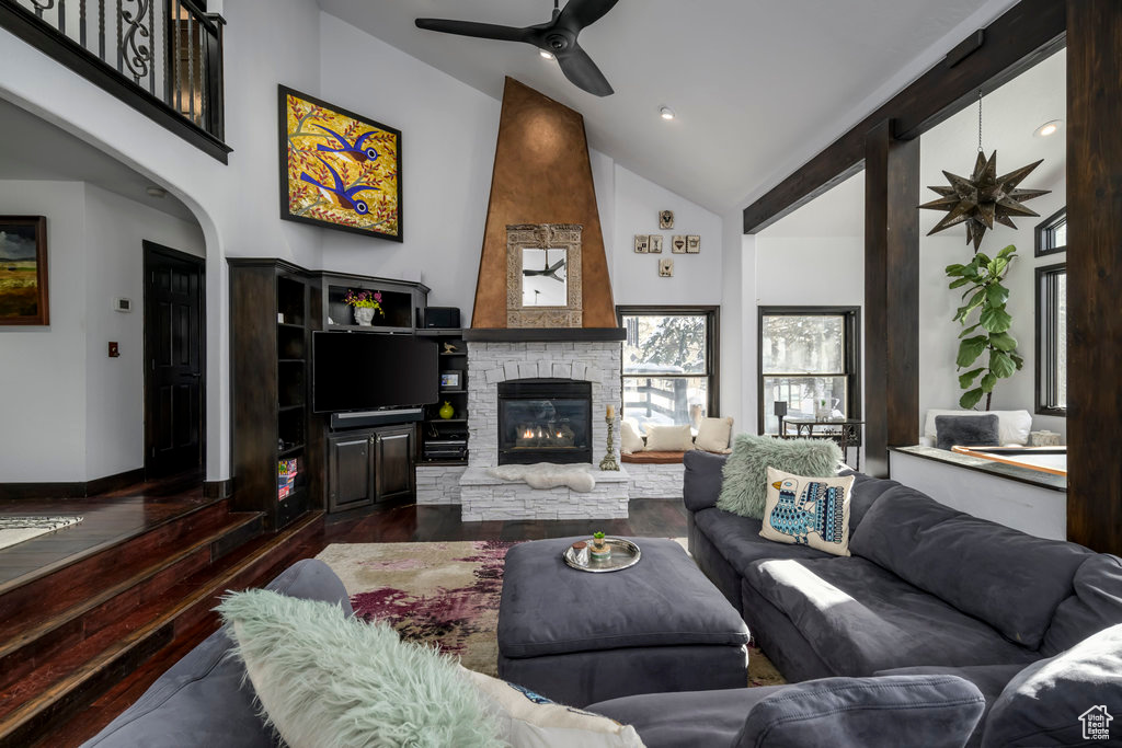 Living room featuring high vaulted ceiling, ceiling fan, a fireplace, and dark hardwood / wood-style floors