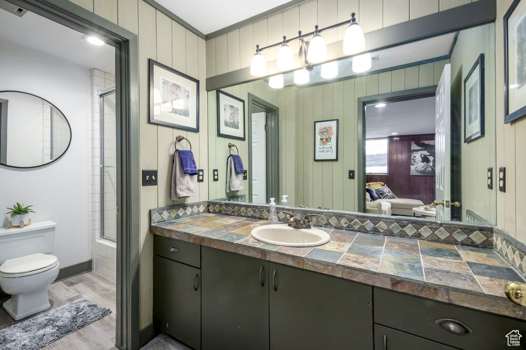 Bathroom with oversized vanity, hardwood / wood-style flooring, toilet, and crown molding