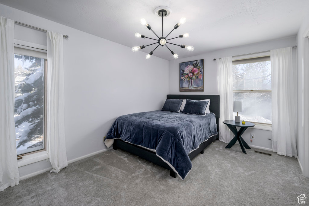 Bedroom featuring a chandelier and light colored carpet