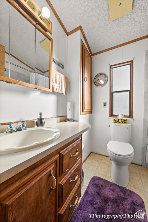 Bathroom featuring tile flooring, a textured ceiling, large vanity, and toilet