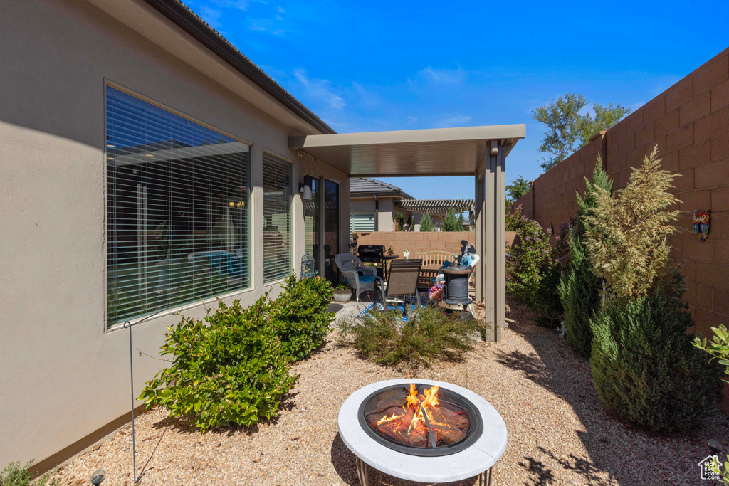 View of yard with an outdoor fire pit and a patio