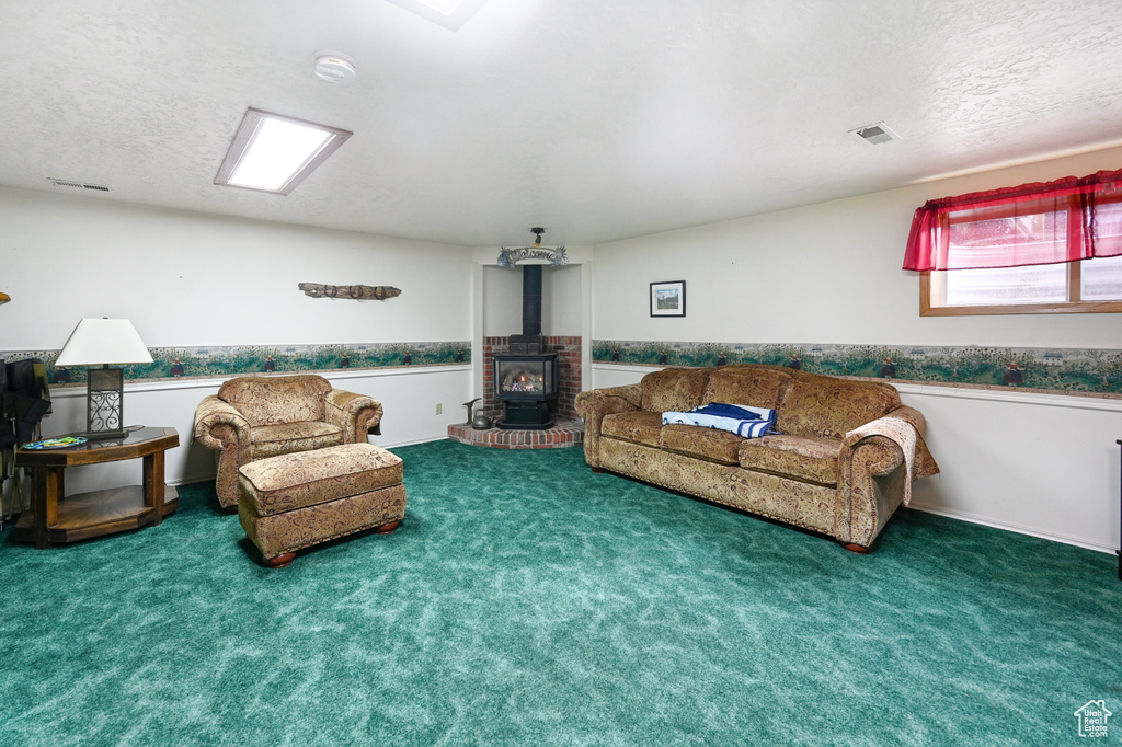 Carpeted living room with a textured ceiling and a wood stove