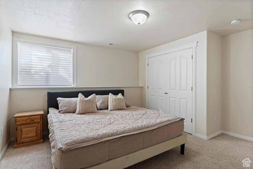 Bedroom featuring a closet and light colored carpet