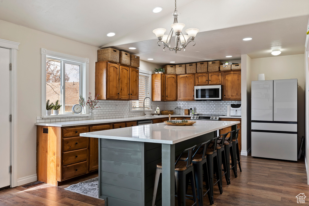 Kitchen featuring a kitchen island, refrigerator, dark hardwood / wood-style flooring, and a notable chandelier