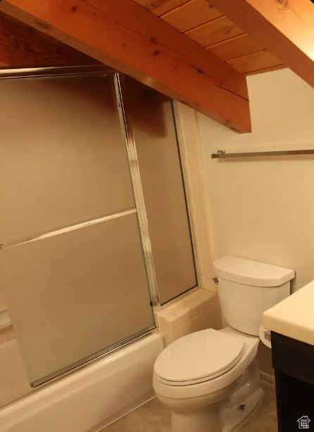 Full bathroom with tile floors, vanity, wood ceiling, toilet, and bath / shower combo with glass door