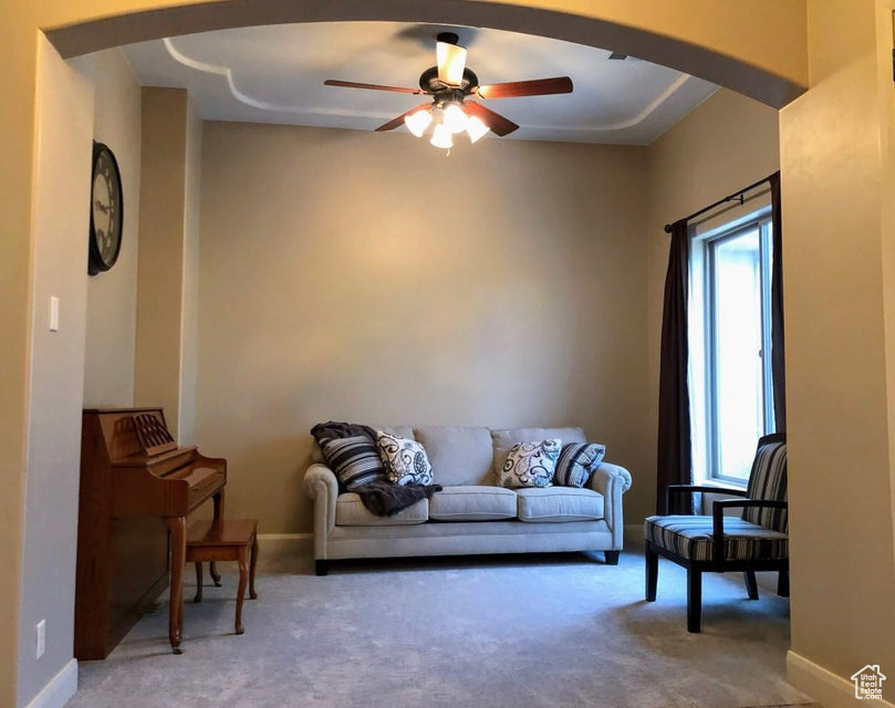 Living room with carpet floors and ceiling fan