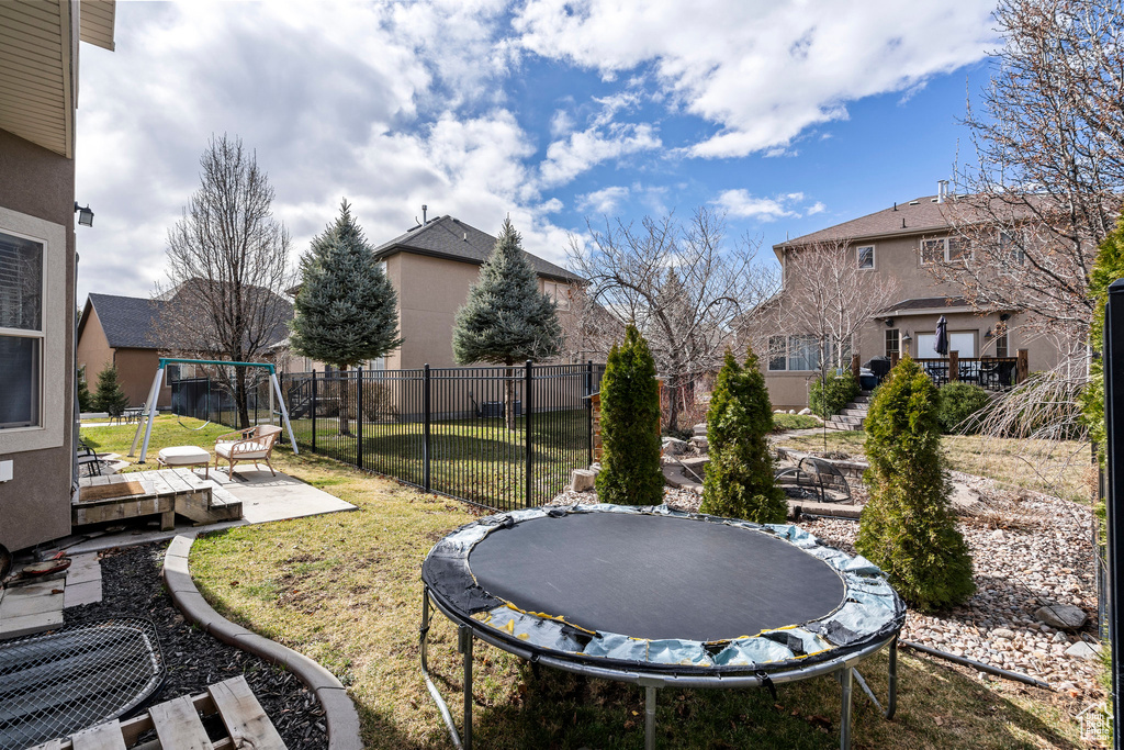 View of yard with a patio area and a trampoline