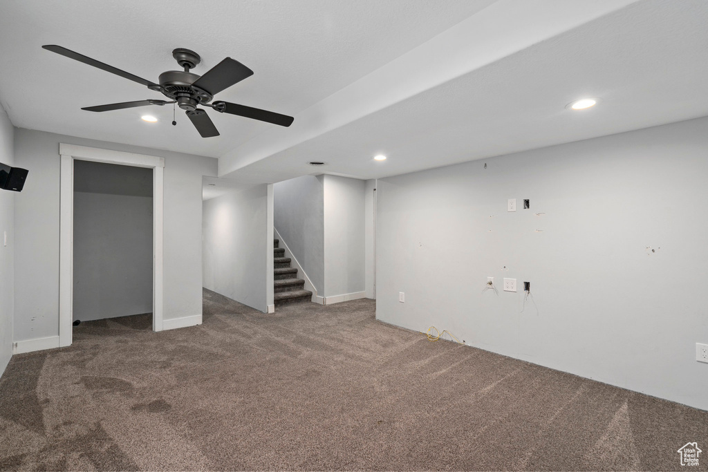 Unfurnished bedroom featuring a closet, dark carpet, and ceiling fan