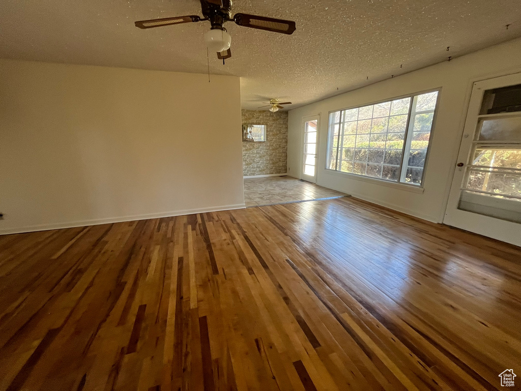 Spare room with ceiling fan, a textured ceiling, and light hardwood / wood-style flooring