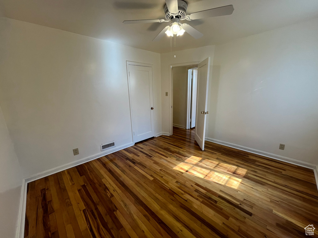 Spare room featuring ceiling fan and dark hardwood / wood-style flooring