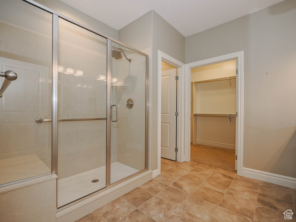 Bathroom featuring walk in shower and tile flooring
