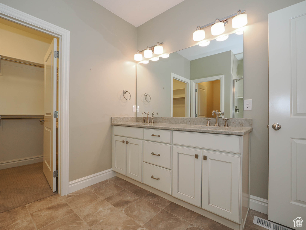Bathroom with dual sinks, tile flooring, and large vanity