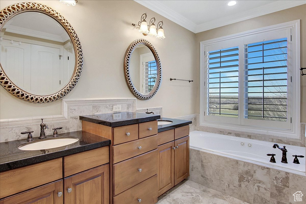 Bathroom with a relaxing tiled bath, double sink vanity, tile floors, and crown molding