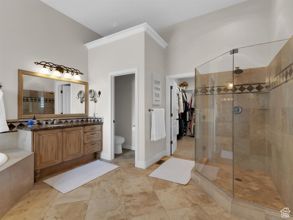 Full bathroom with tile flooring, separate shower and tub, and vanity