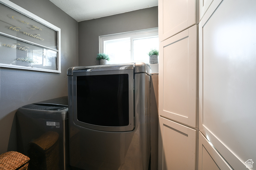 Laundry area with cabinets and separate washer and dryer