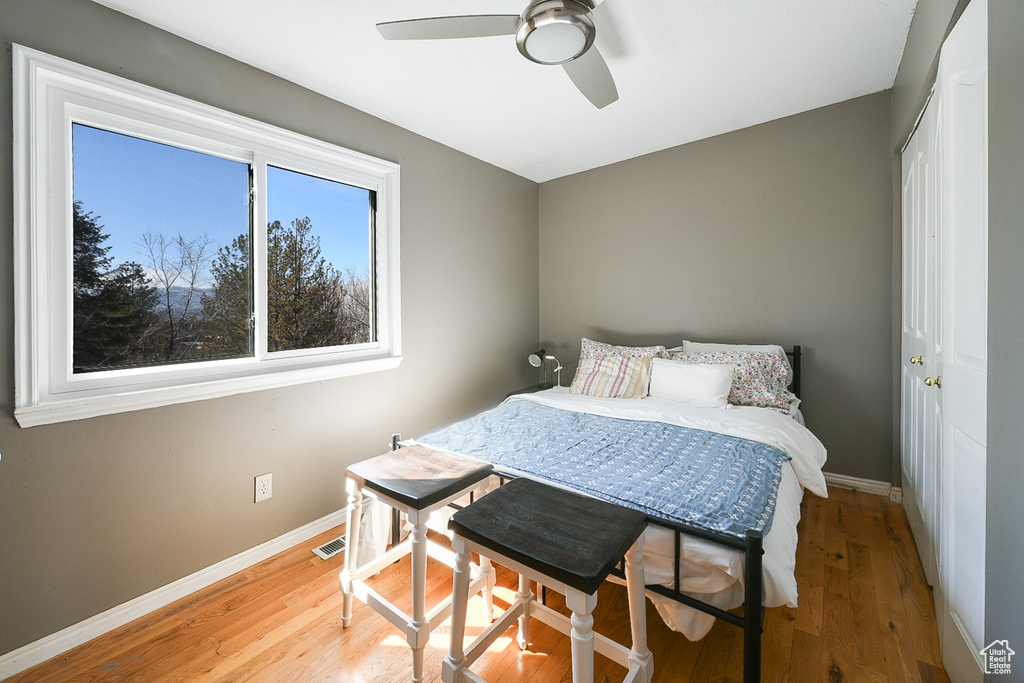 Bedroom featuring light wood-type flooring, ceiling fan, and a closet