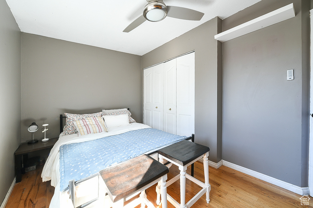 Bedroom with light hardwood / wood-style flooring, a closet, and ceiling fan