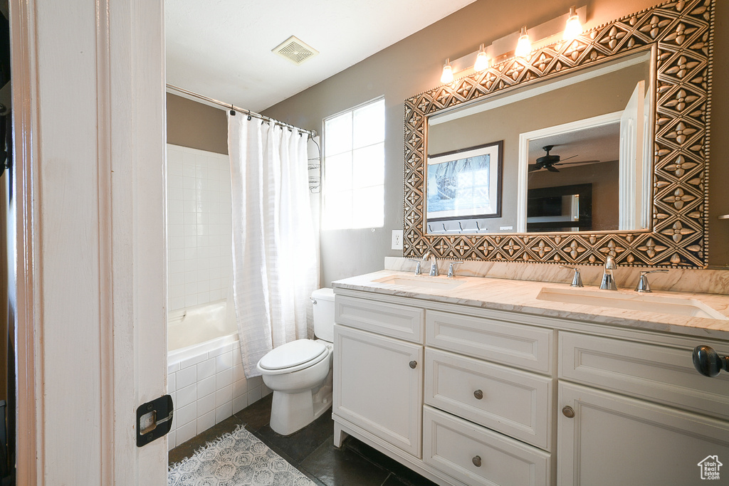Full bathroom with double sink, tile floors, shower / tub combo, toilet, and oversized vanity