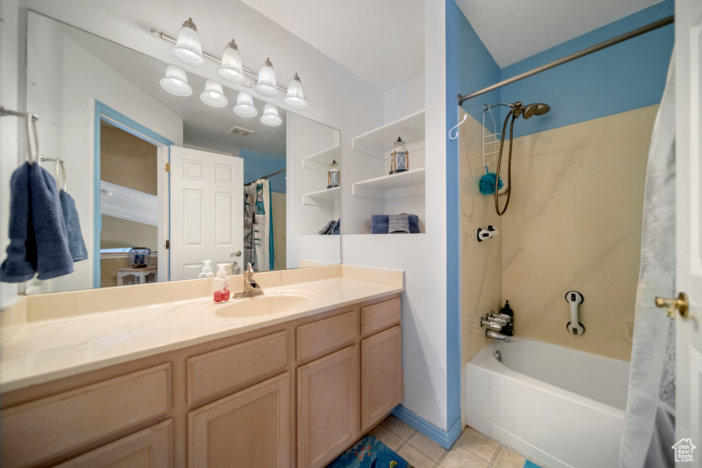Bathroom featuring vanity, shower / bath combo, and tile floors