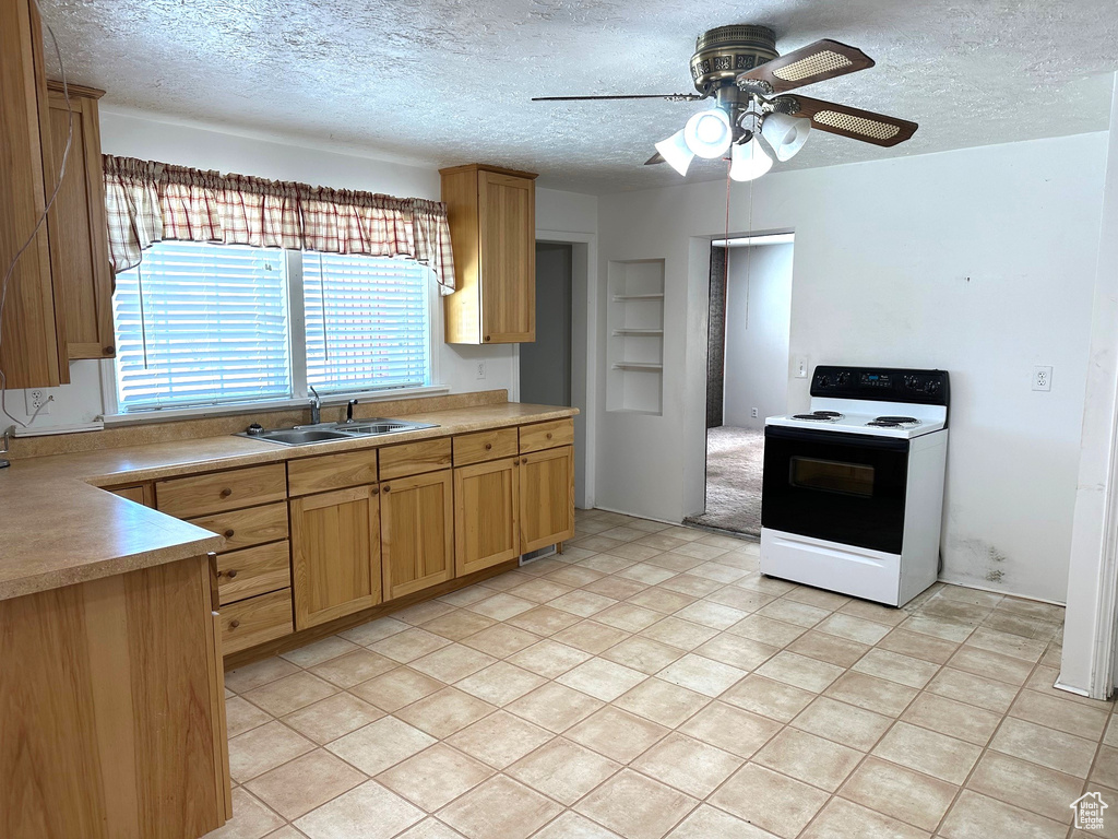 Kitchen featuring a textured ceiling, light tile floors, ceiling fan, sink, and white electric range