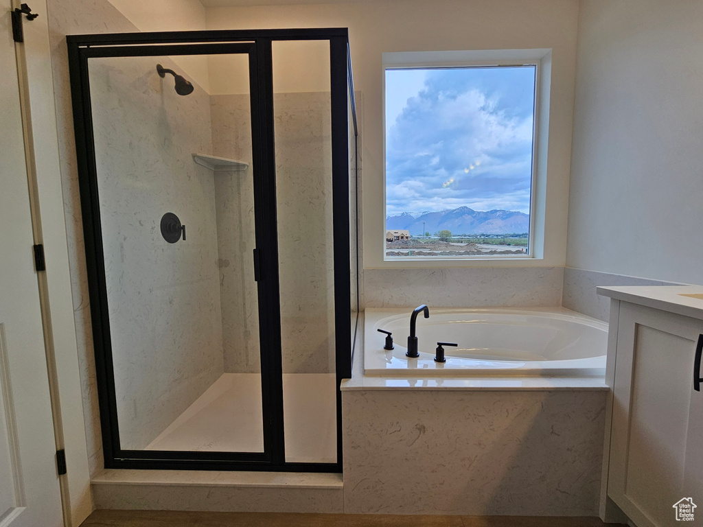 Bathroom with a mountain view, a healthy amount of sunlight, and separate shower and tub