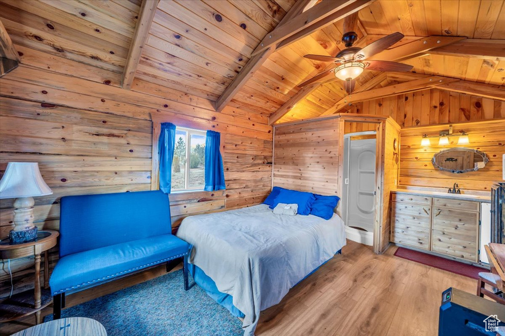 Bedroom featuring light hardwood / wood-style flooring, wooden walls, wooden ceiling, and ceiling fan