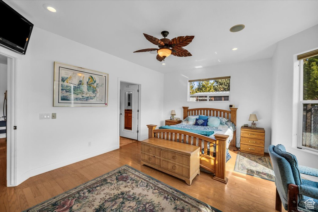 Bedroom featuring light hardwood / wood-style flooring, multiple windows, and ceiling fan