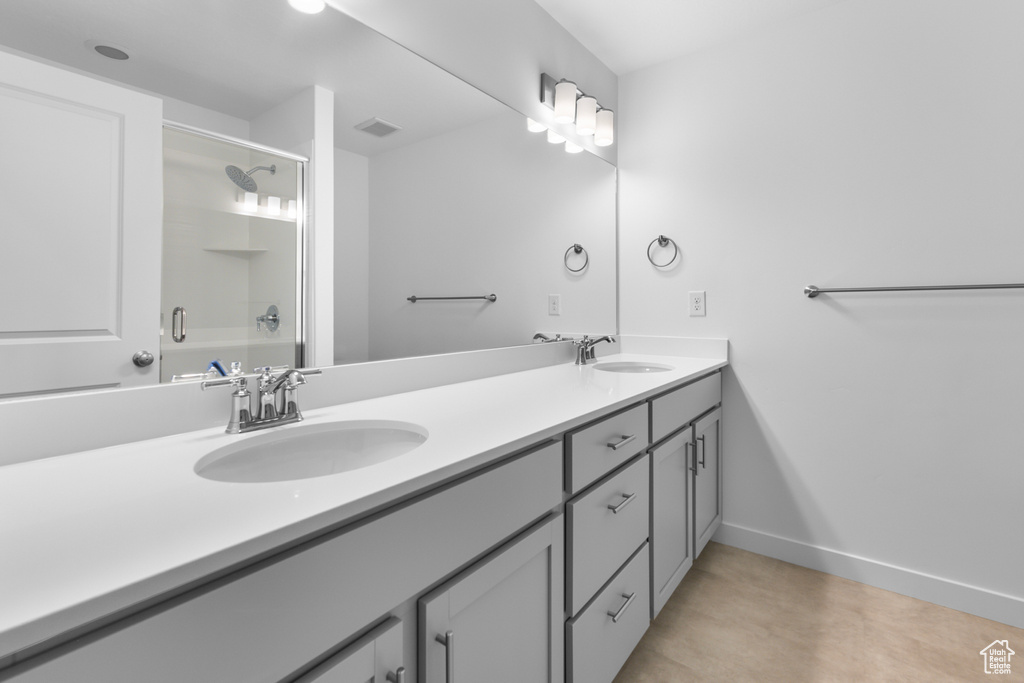 Bathroom featuring dual sinks, tile floors, and large vanity
