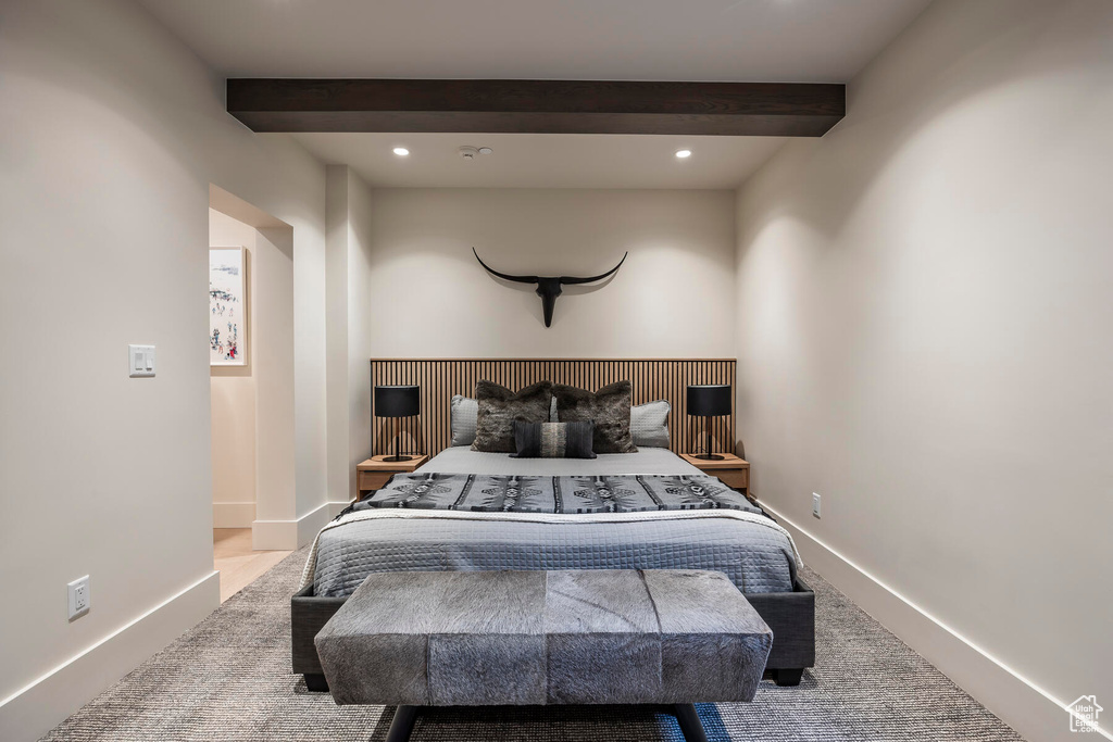 Carpeted bedroom featuring beam ceiling
