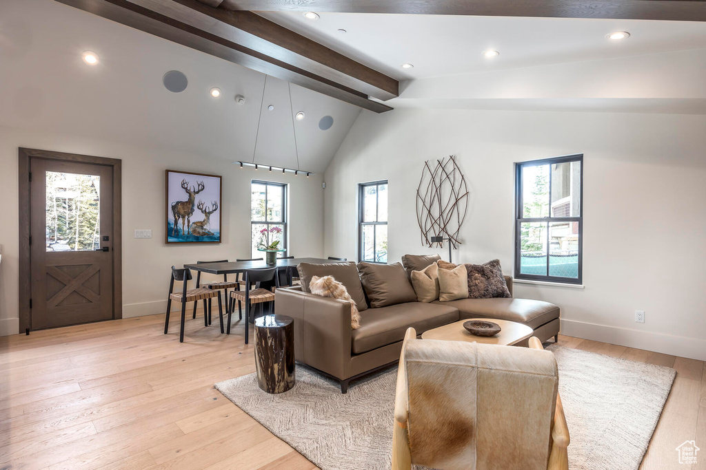 Living room featuring plenty of natural light, beam ceiling, and light hardwood / wood-style floors