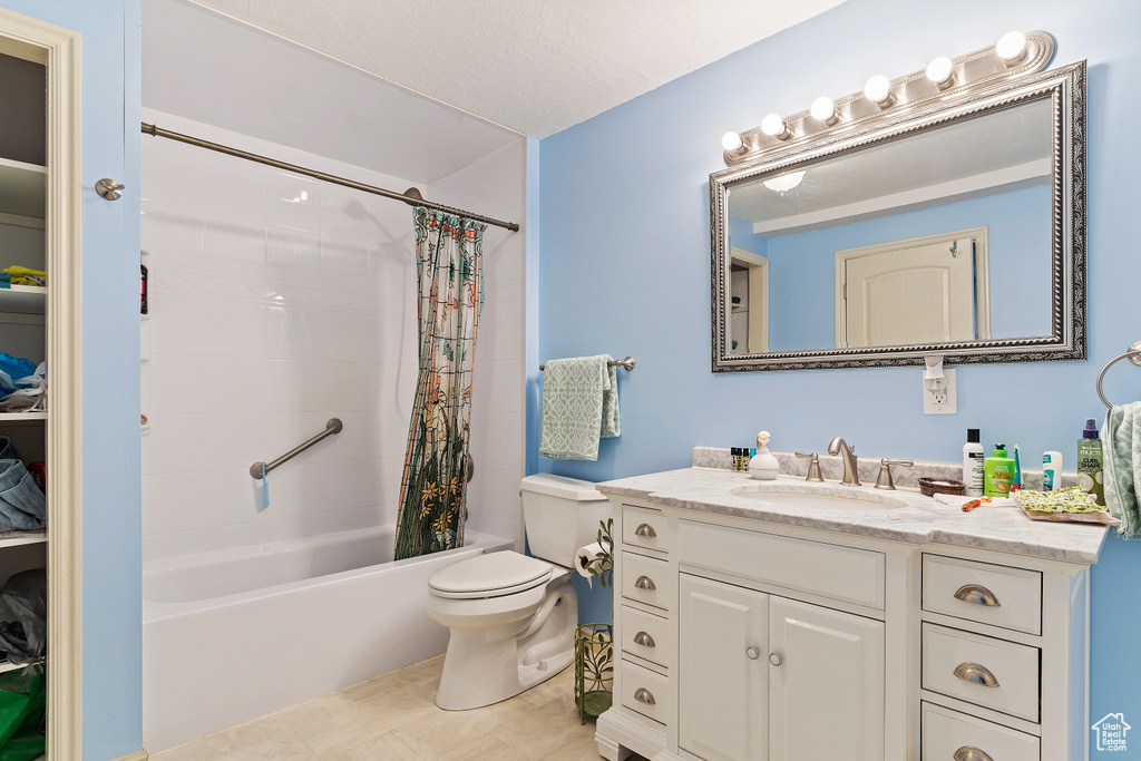 Full bathroom featuring shower / tub combo, tile floors, large vanity, and toilet