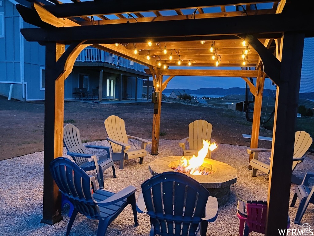 View of patio / terrace with an outdoor fire pit, a mountain view, and a pergola