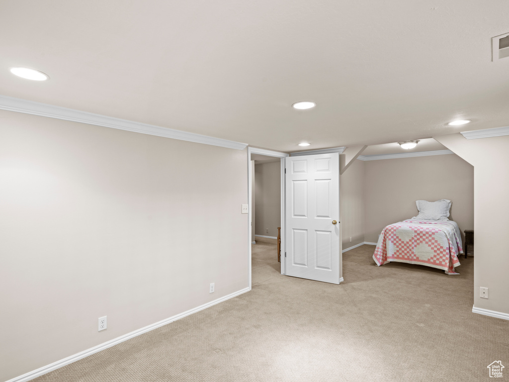 Unfurnished bedroom featuring light colored carpet and ornamental molding