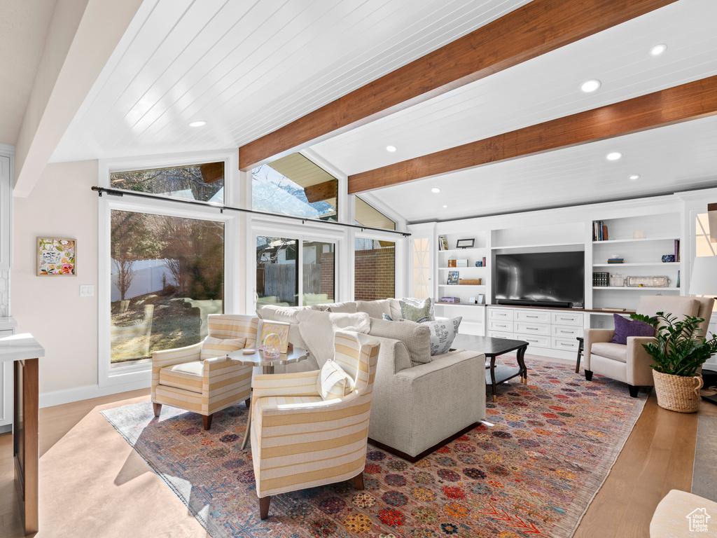 Living room featuring lofted ceiling with beams and light hardwood / wood-style flooring