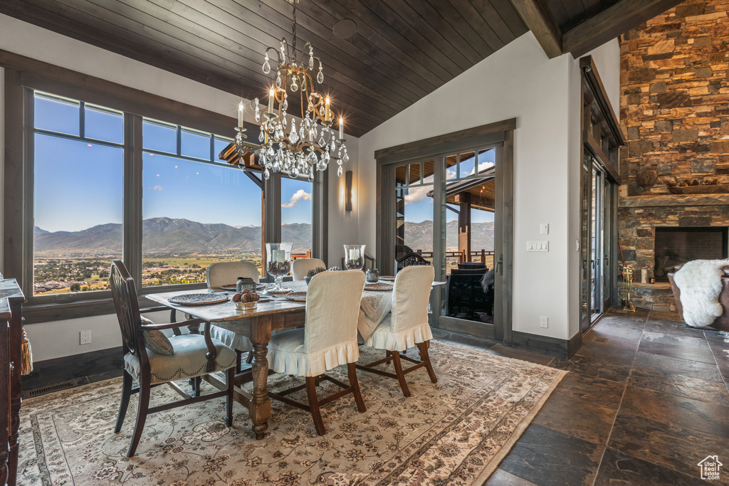 Tiled dining area with an inviting chandelier, a mountain view, wooden ceiling, and high vaulted ceiling