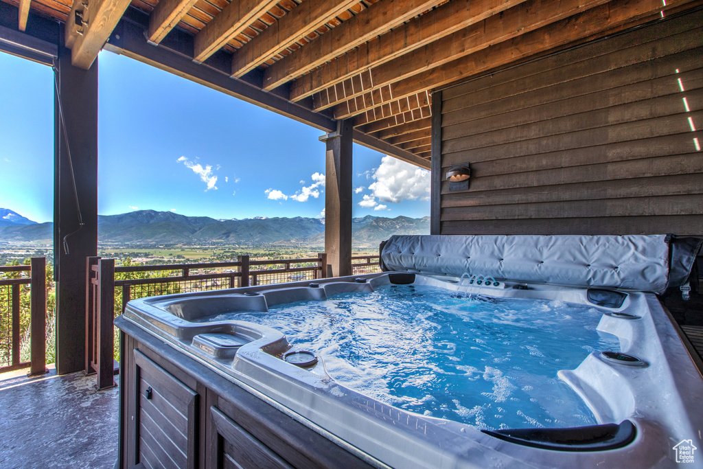 View of pool with a hot tub and a mountain view