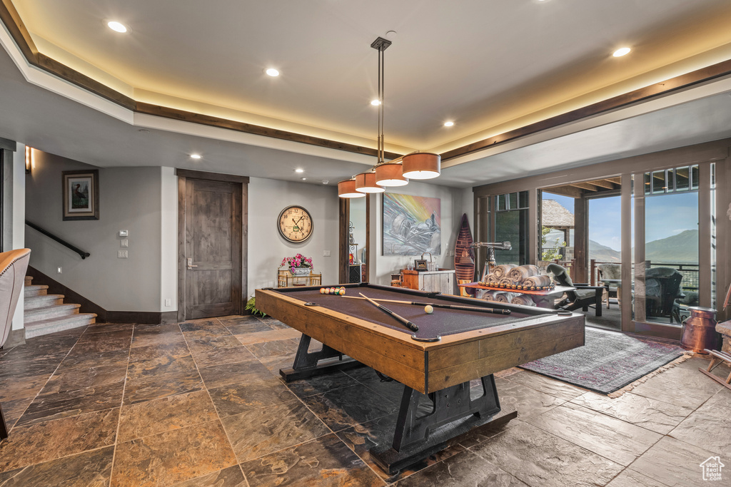 Rec room featuring billiards, a tray ceiling, and dark tile floors