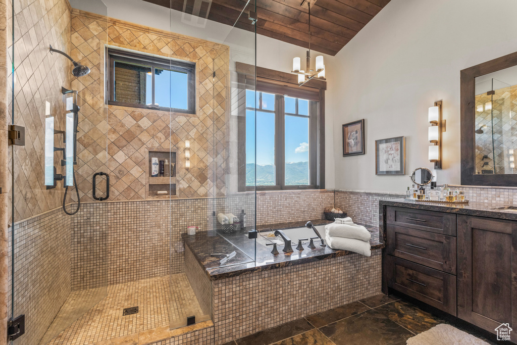 Bathroom featuring oversized vanity, plus walk in shower, a healthy amount of sunlight, and wood ceiling